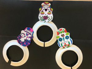 three colorful sugar skulls over a black background