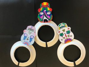 three colorful sugar skulls created by students over a black backdrop