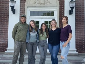 Five students sit in front of Middleburgh Central School.