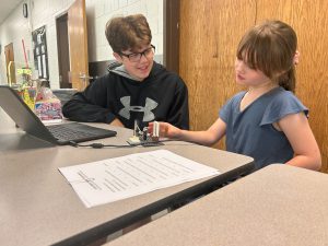 Teen and younger student work on Lego kit.