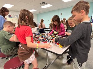 Group of students and table of Lego blocks.