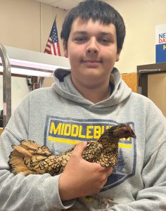 Teen holding chicken.