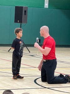 Boy stand in front of kneeling man.