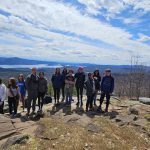 Group stands together for mountain top photo in the Adirondacks.