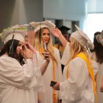 Students wearing graduation caps and gowns.