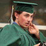 Student wearing graduation cap and gown.