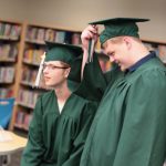 Students wearing graduation caps and gowns.