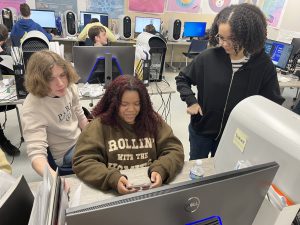 Students work at a computer monitor.