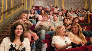 Students seated in ornate theater.