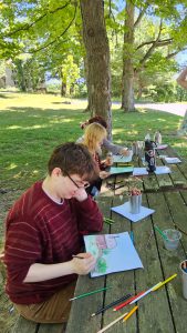 Students sketching at picnic table.