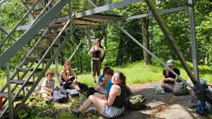 Students gather for a snack in shade of fire tower.