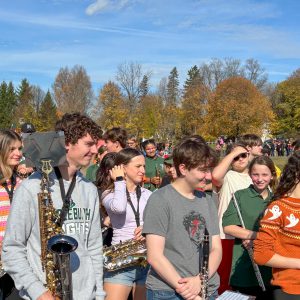 Members of marching band hold their instruments as they prepare to play outdoors.