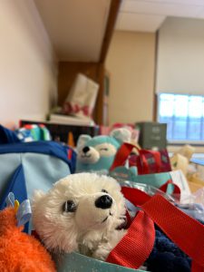 Rows of gift bags, some with stuffed animals peeking out of the top.