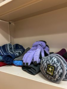 Hats and gloves on a shelf.