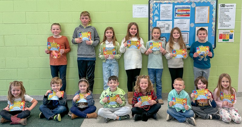 Fifteen students stand together. They are holding certificates and smiling.