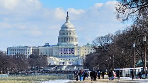 U.S. Capitol in the background with people walking in foreground.