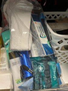 Personal care items such as toothpaste, soap and a wash cloth in a clear bag.